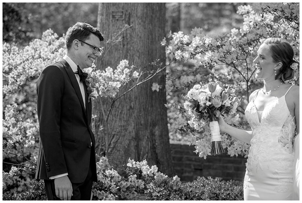 Bride smiles as her groom sees her dress for the first time inside the azalea garden at the National Arboretum in DC.