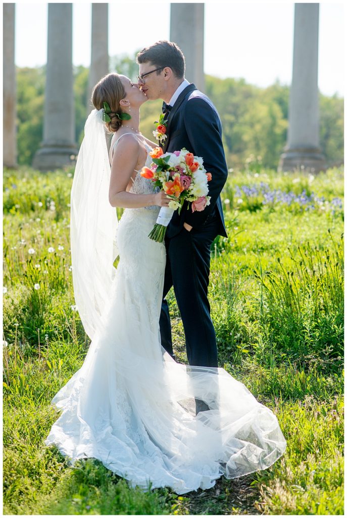 Wedding couple kiss in front of historic Capitol Columns at the U.S. National Arboretum in DC.