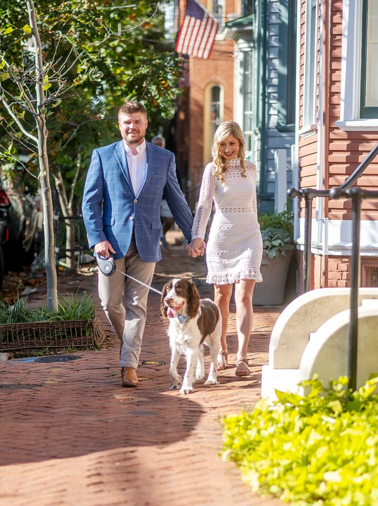 Couple walks dog during engagement session in Annapolis by Annapolis Wedding Photographer Nadine Nasby Photography.