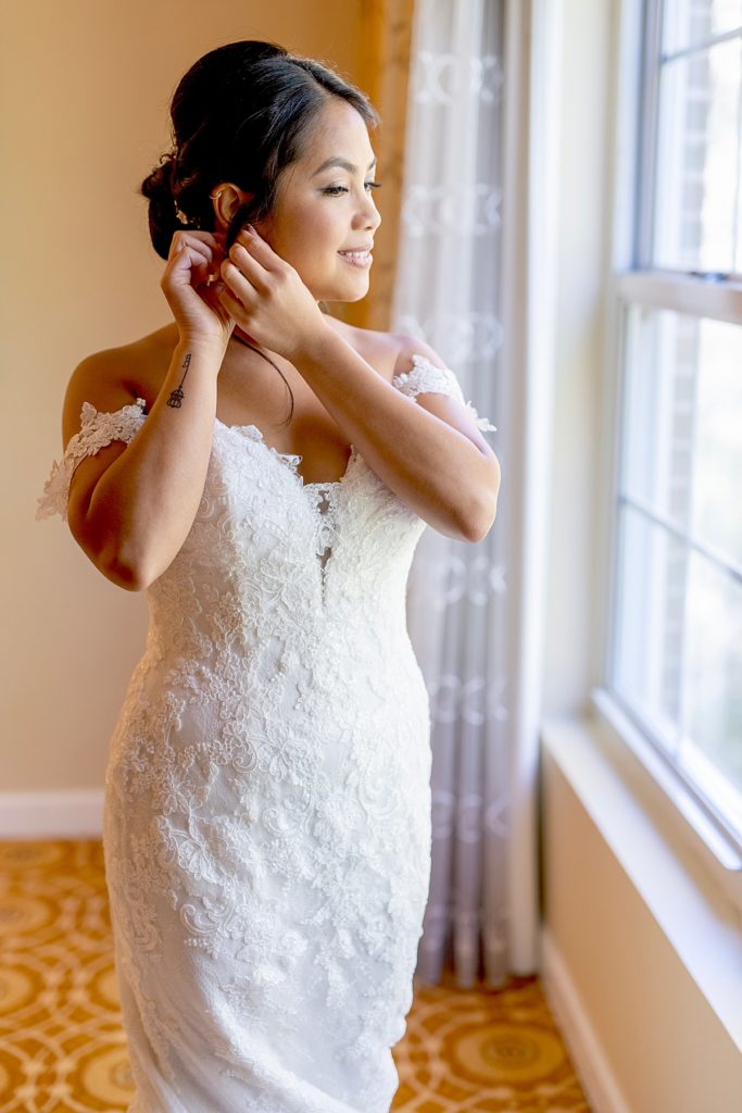 Bride puts on earrings for her DC wedding.