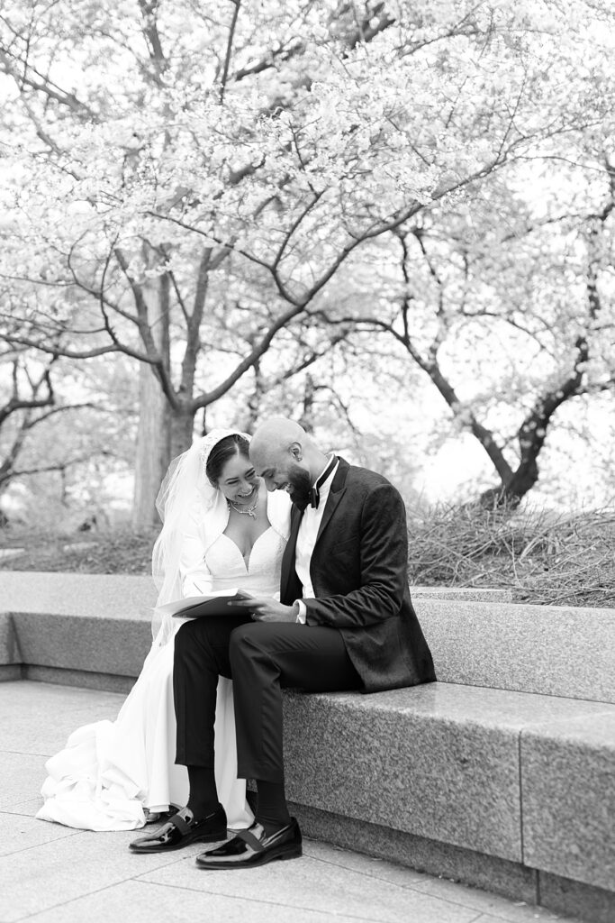 Bride and groom sign marriage license under cherry blossom trees - DC War Memorial wedding