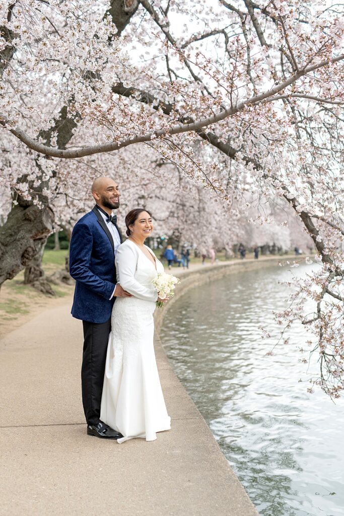 DC War Memorial Wedding Bride and Groom admire cherry blossoms