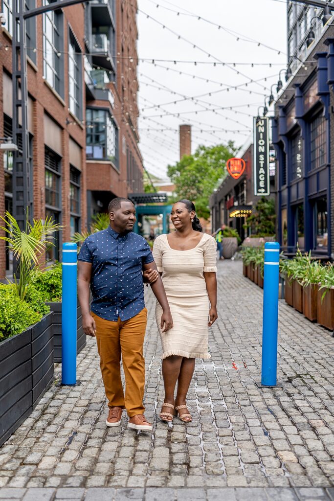 Couple walk down Pearl Street at The Wharf for their engagement photos.
