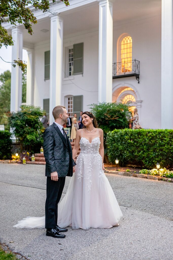 Bride and groom in front of their wedding venue - Grey Rock Mansion in Maryland