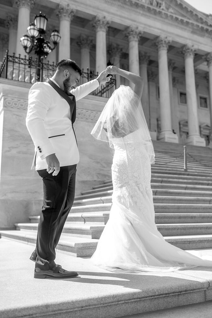 Bride shows off dress to groom at the US Capitol before their wedding at DC Dock 5 in Union Market.