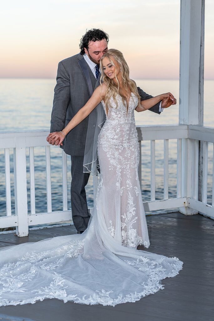 Bride and groom dance at sunset on the waterfront patio overlooking the Chesapeake Bay at Kurtz Beach in Maryland