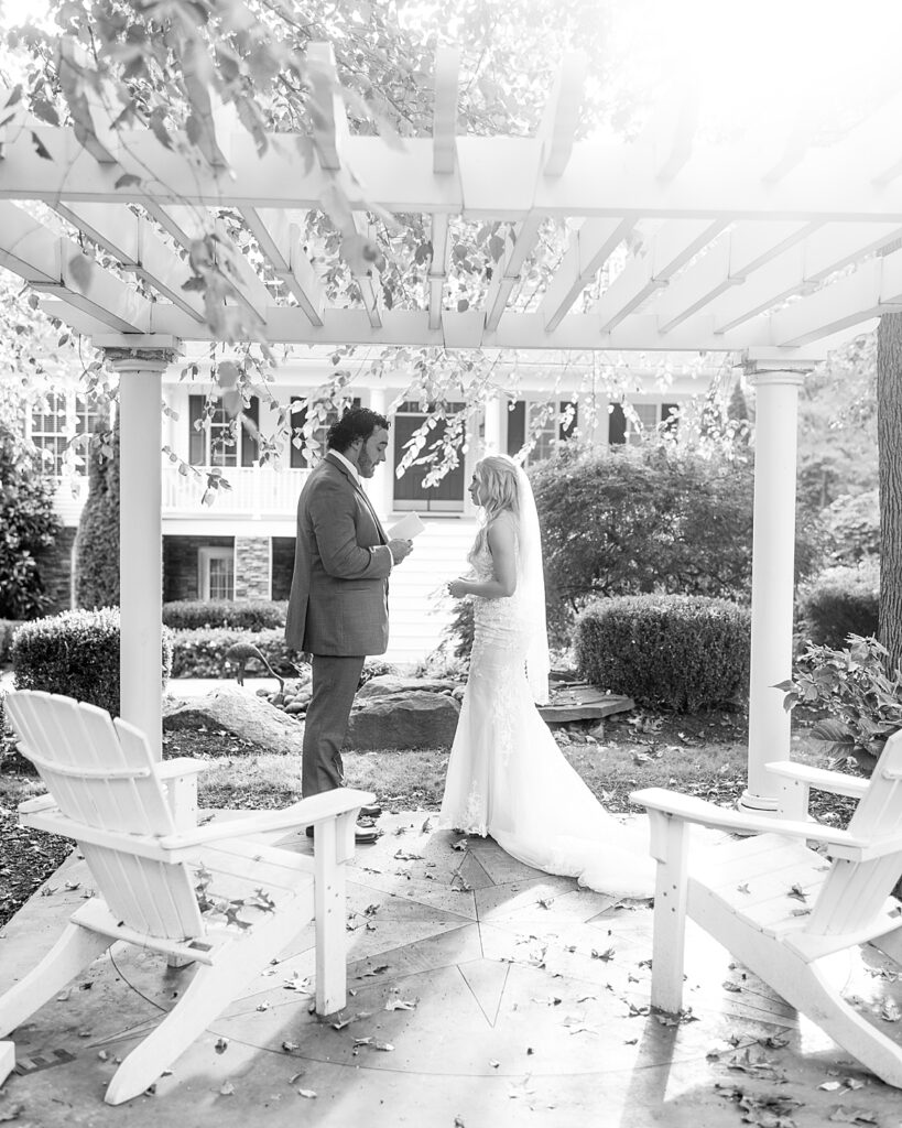 Bride and groom exchange personal handwritten vows under a pergola at one of the cottages of Kurtz Beach. Photo by Maryland wedding photography Nadine Nasby Photography