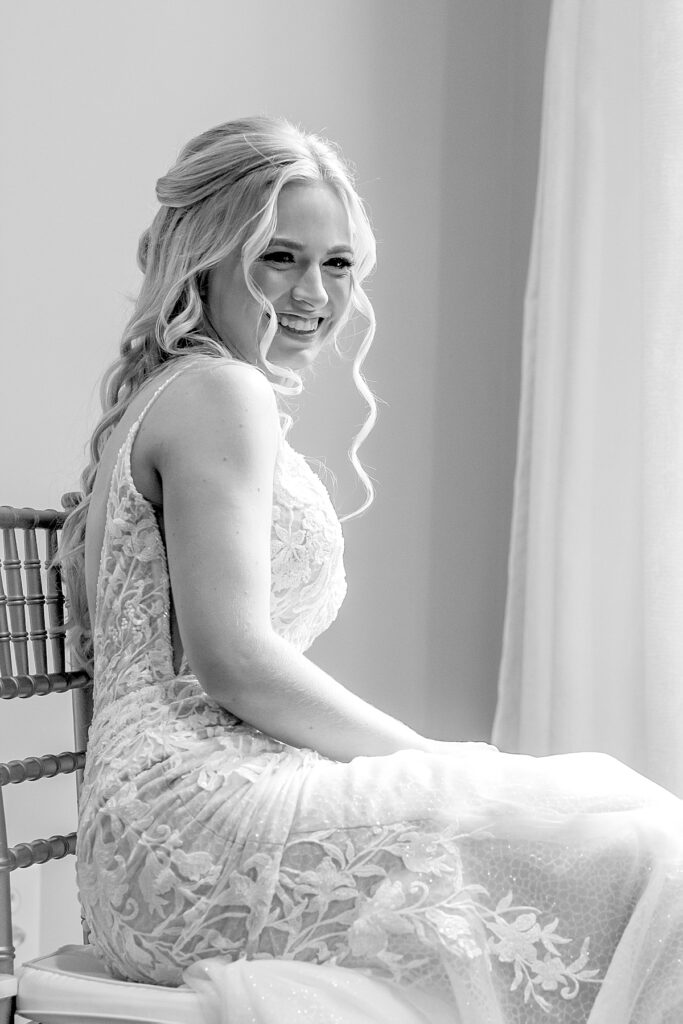 Bride giggles by window in dressing cottage at Kurtz Beach. Photo by Maryland wedding photographer Nadine Nasby Photography