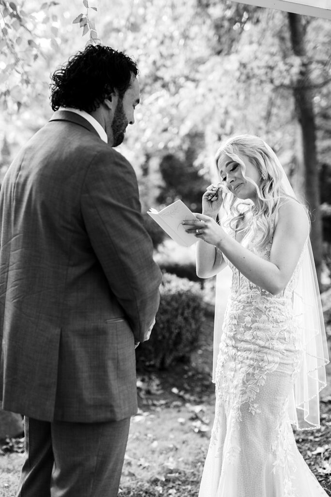 Bride cries as she reads her personal vows to her groom in a private place before their ceremony.