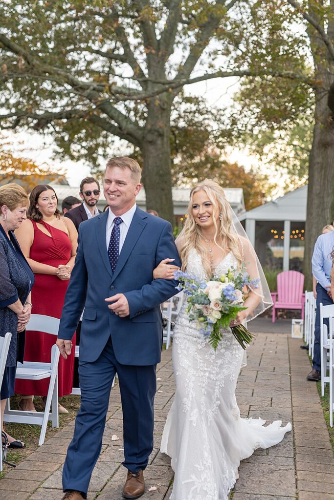 Father of the bride walks his daughter down the aisle to her groom at Kurtz Beach