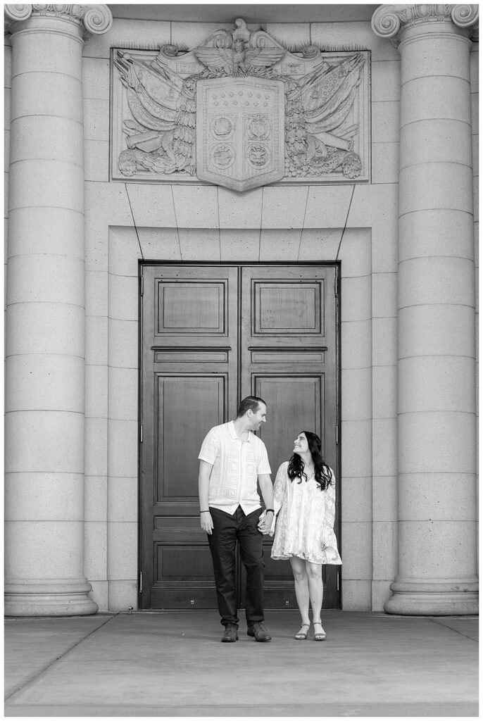 Couple walk by the event space of Union Station for their Washington DC engagement photographer