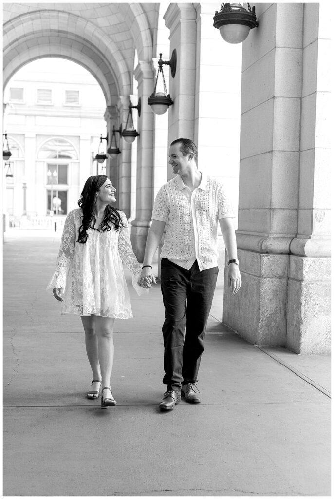 Washington DC engagement photographer catches couple as they walk holding hands in front of Union Station.