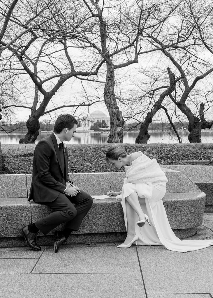 Couple sign their marriage license with Jefferson Memorial in background 