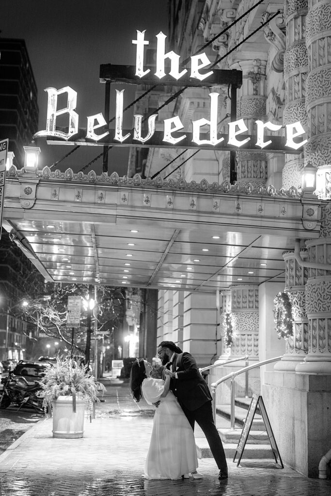 Bride and groom dip in front of their wedding venue at night in Baltimore.