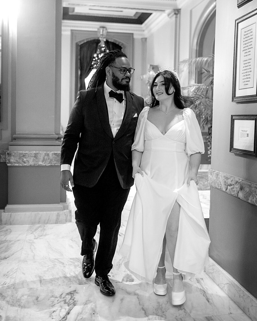 Bride and groom walk through the lobby of The Belvedere Co & Events