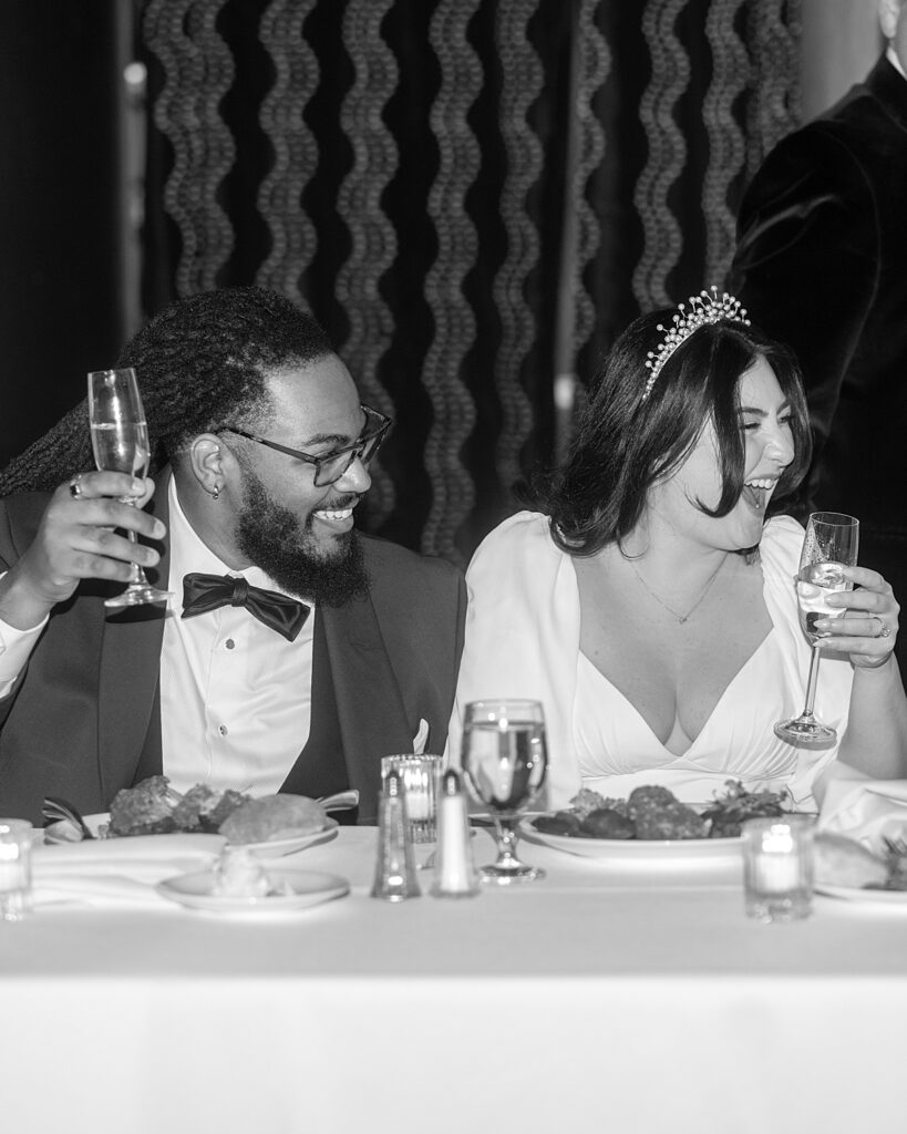 Wedding couple laugh in reaction to a speech at their wedding reception - documentary style wedding photographer DC.