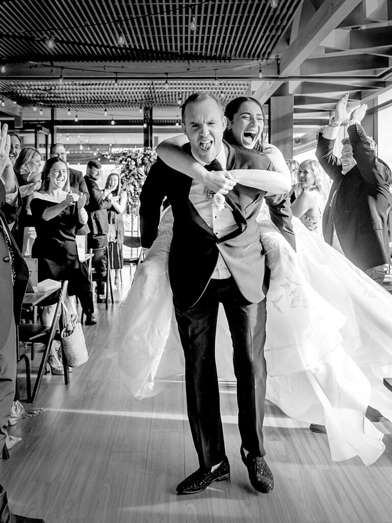 Bride and groom ethusiastically enter wedding reception at District Winery DC